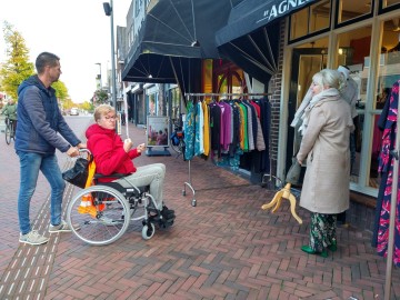 Hetty Pullen-Muis en Koen Meesters ervaren op uitnodiging van het Gehandicapten Platform Hoogeveen hoe het is om in een rolstoel en met een blindenstok rond te bewegen in Hoogeveen.